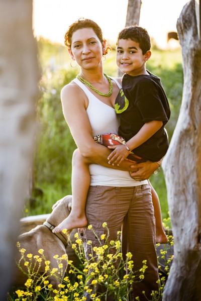 Hispanic mother carrying son in garden