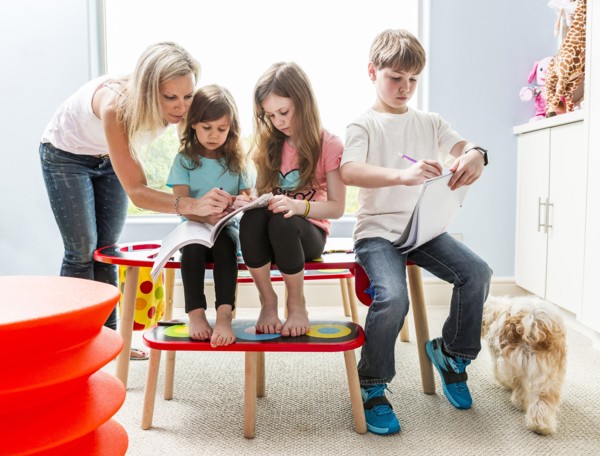 Caucasian family drawing at table in playroom