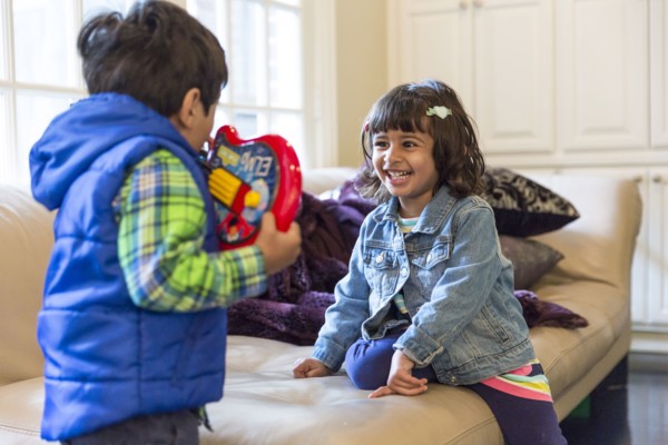 Brother and sister playing with toy in living room