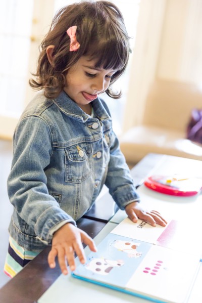 Close up of girl reading book at table