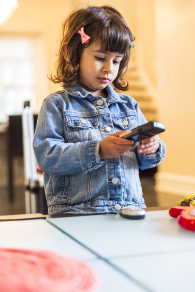 Girl watching television with remote control