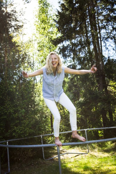 Woman jumping from metal structure in backyard