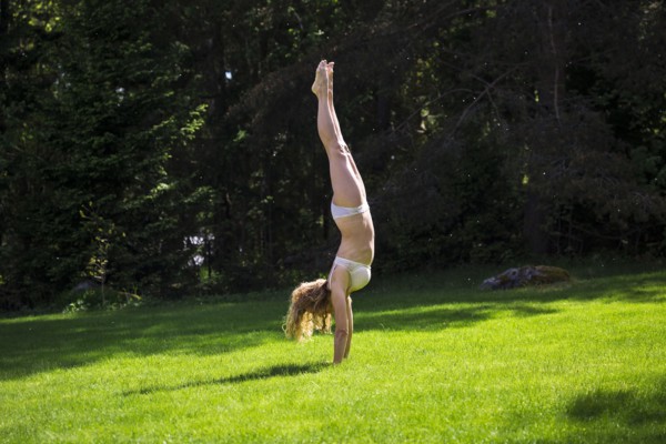 Woman doing handstand in backyard