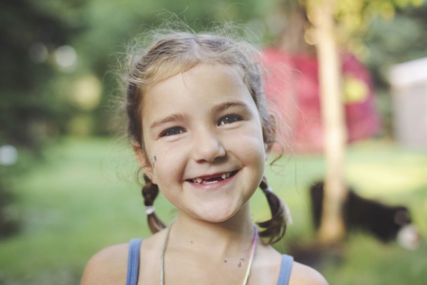 Caucasian girl smiling in backyard
