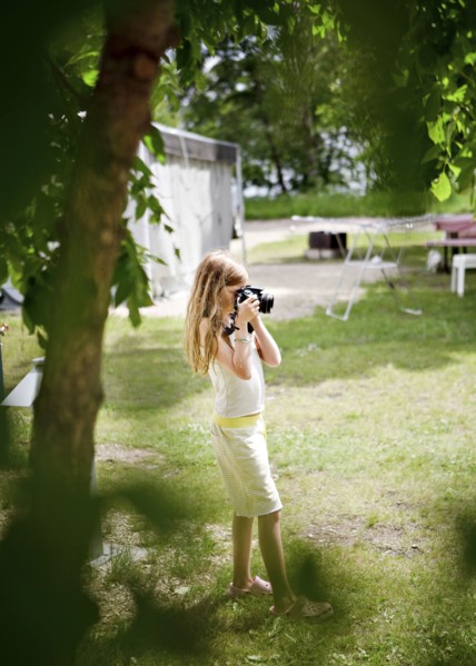 Caucasian girl photographing in backyard