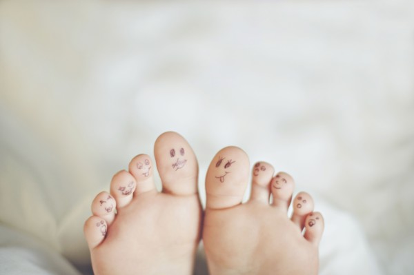 Toes of Caucasian girl with smiley face drawings