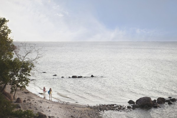 Caucasian girls standing on remote beach
