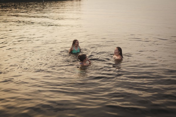Caucasian girls swimming in lake