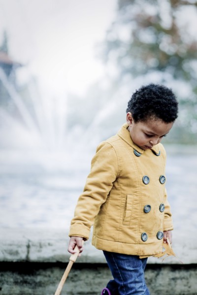 Girl in yellow coat walking in park