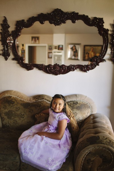 Hispanic girl sitting on living room sofa