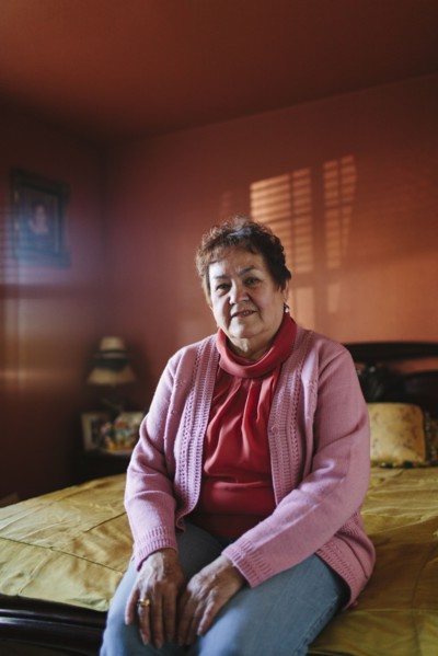 Hispanic woman sitting on bed