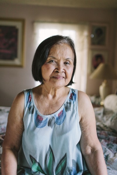 Smiling older woman sitting on bed