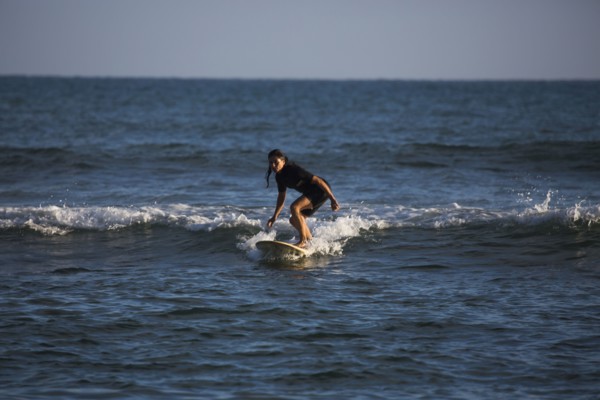Hispanic woman surfing in ocean