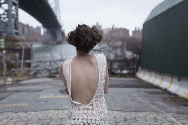 Woman in low-back dress walking in industrial area