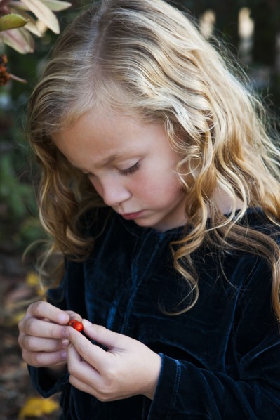 Close up of girl examining berry outdoors