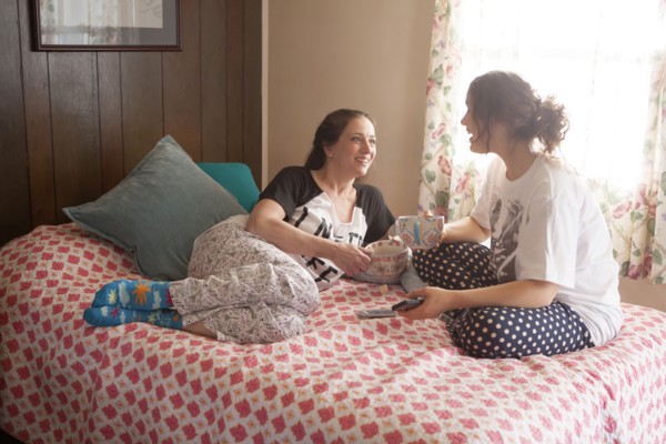 Caucasian mother and daughter playing cards in bedroom