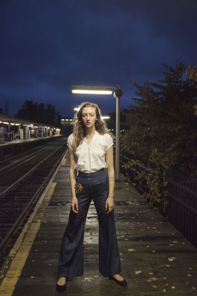 Woman waiting for train at train station at night