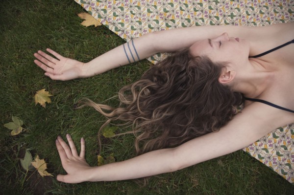 Woman laying on blanket in grass