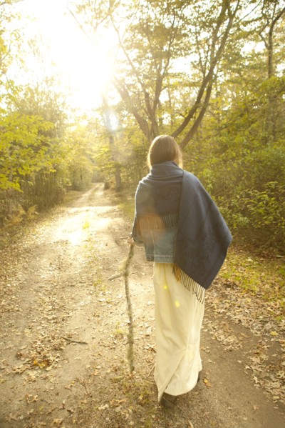 Woman walking on dirt path in forest