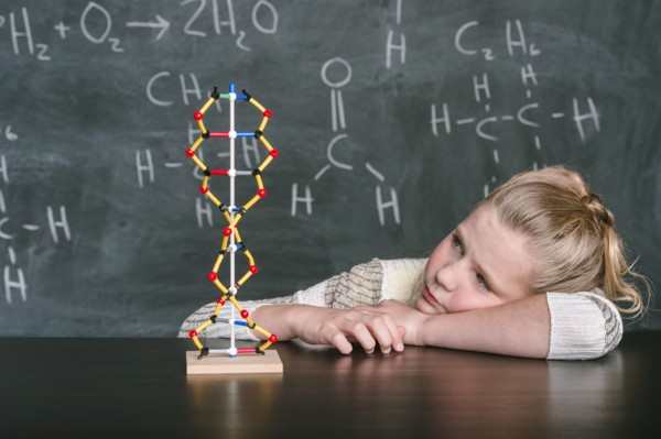 Caucasian student examining molecular model in science class
