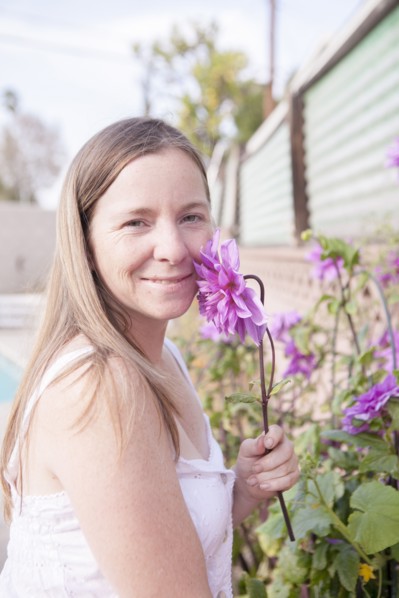 Mixed race woman smelling flowers in garden