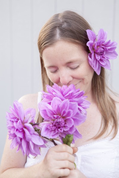 Mixed race woman smelling flowers