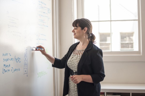 Caucasian businesswoman writing on whiteboard in office