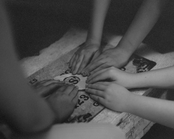 High angle view of children playing with ouija board