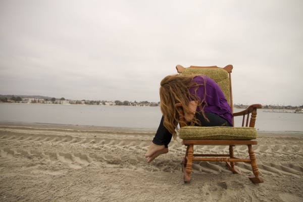 Woman sitting in armchair on beach