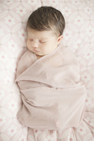 Caucasian baby girl swaddled in blanket