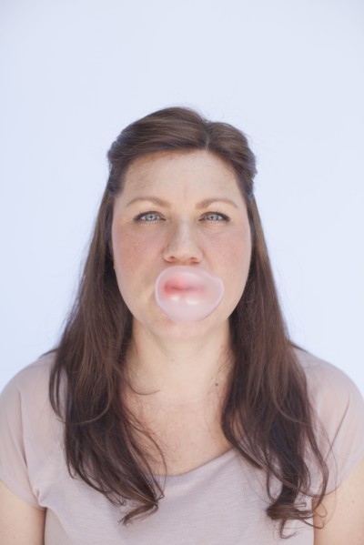 Caucasian woman blowing bubble with gum