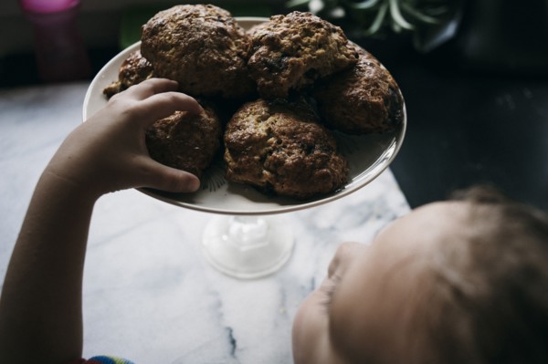 Girl reaching for cookie on kitchen counter