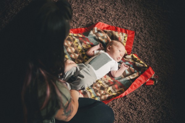 Mother playing with baby daughter on blanket