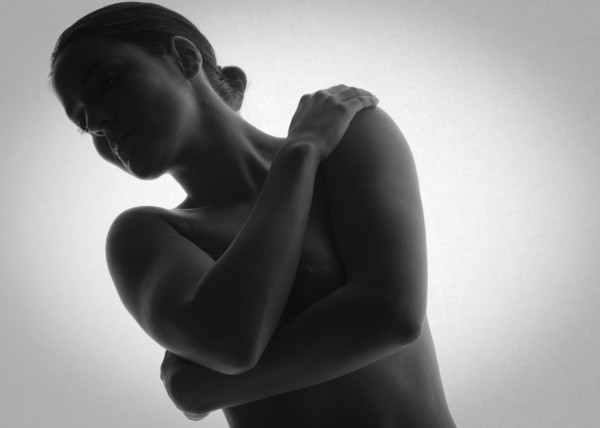 Nude woman covering her breasts