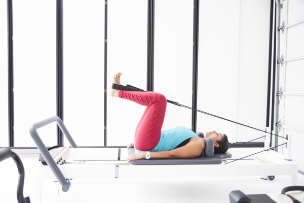 Asian woman using exercise machine in gymnasium