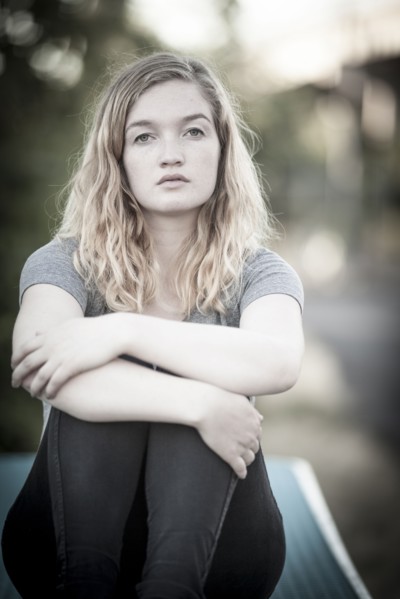 Serious woman hugging her knees