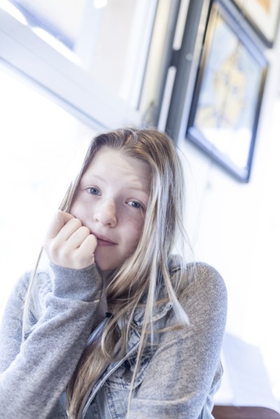 Serious girl resting chin in hand