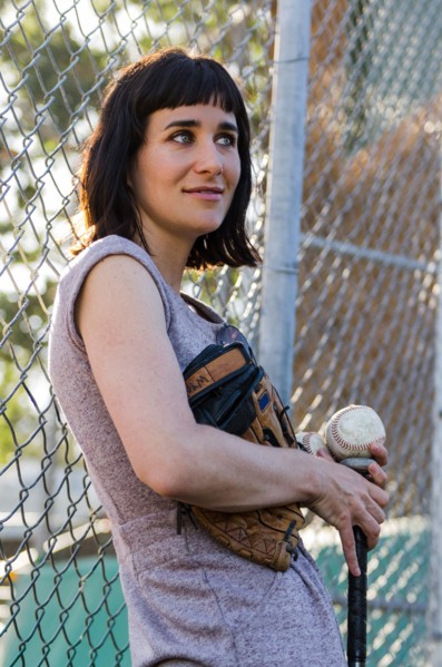 Baseball player leaning on fence