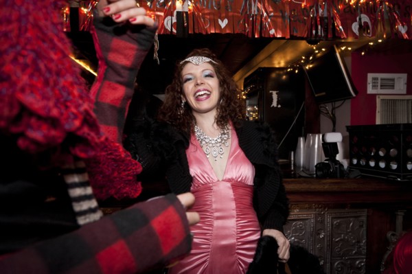 Smiling woman cheering in bar