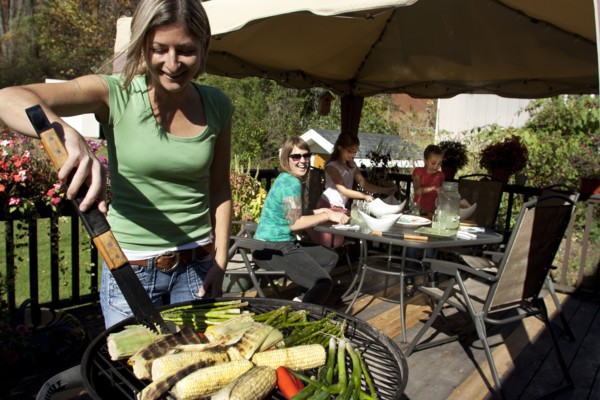 Woman grilling vegetables on patio