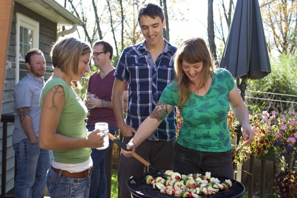Friends grilling vegetables in backyard