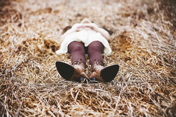 Caucasian teenage girl laying in tall grass