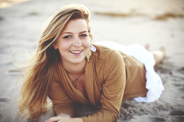 Close up of smiling woman laying on beach