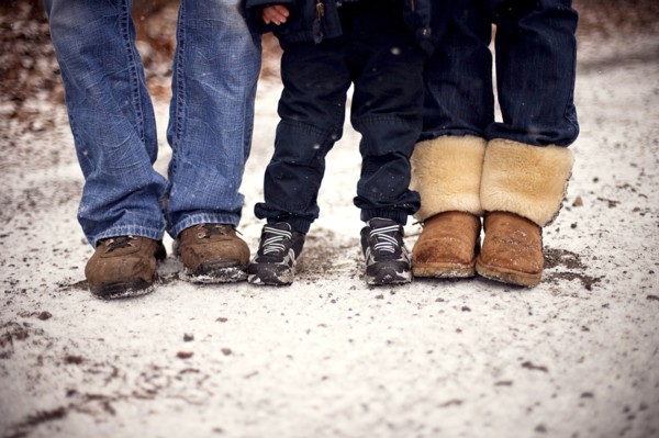 Close up of boots of family standing in snow
