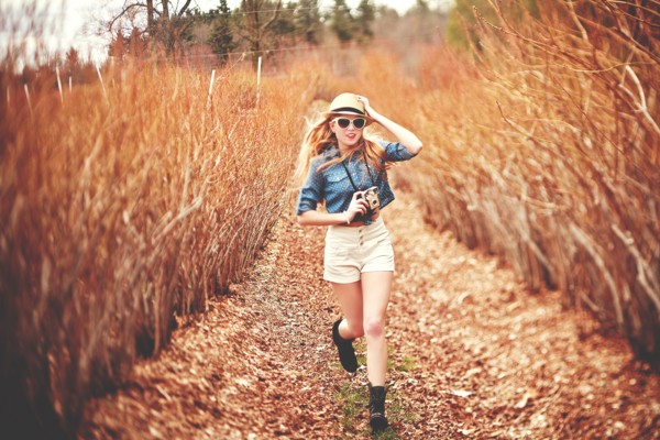 Caucasian woman carrying instant camera on dirt path