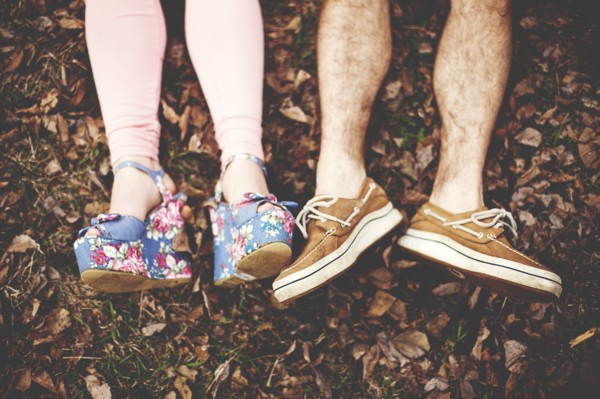 Close up of shoes of couple laying in autumn leaves