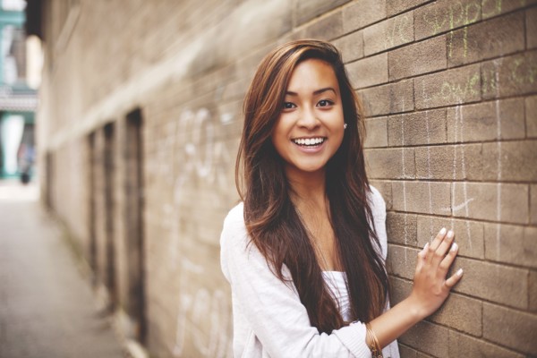 Woman standing at brick wall in city