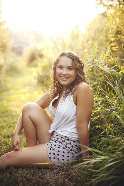 Smiling woman sitting in rural field