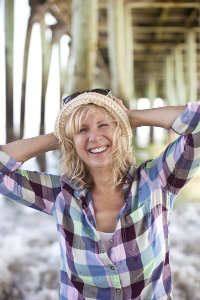 Caucasian woman standing under boardwalk on beach
