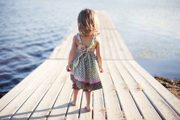 Girl walking on wooden dock over rural lake